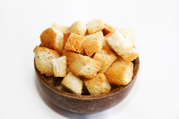 fried dry white bread crackers in a wooden plate on a white background