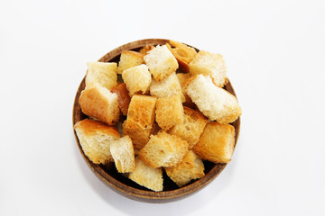 fried dry white bread crackers in a wooden plate on a white background
