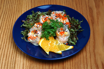 Seafood platter with lemon and parsley on a blue plate