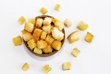 fried dry white bread crackers in a wooden plate on a white background