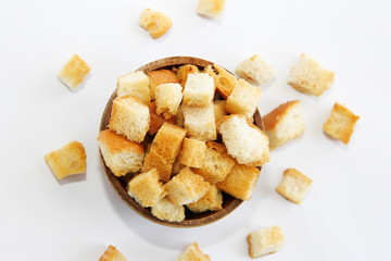 fried dry white bread crackers in a wooden plate on a white background