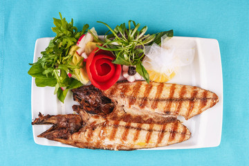Seafood, Mediterranean cuisine. Grilled Seafood Steak fish with greens, cucumber, lemon and chili. Japanese food