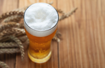 A glass of cold beer on a wooden table