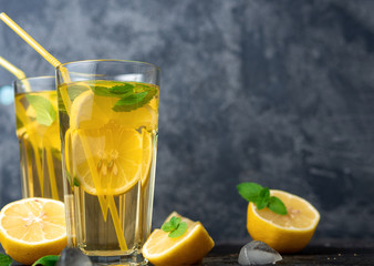 Summer cold homemade Mojito tea with mint and lemon and ice .