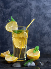 Summer cold homemade Mojito tea with mint and lemon and ice .