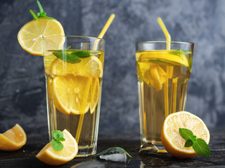 Summer cold homemade Mojito tea with mint and lemon and ice .