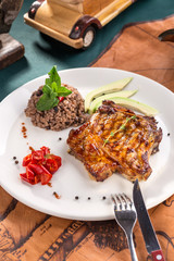 pork chop steak with steamed brown rice on old map background