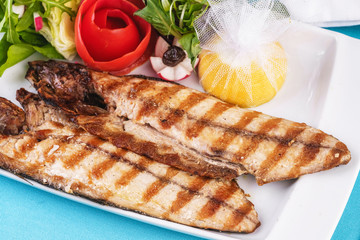 Seafood, Mediterranean cuisine. Grilled Seafood Steak fish with greens, cucumber, lemon and chili. Japanese food