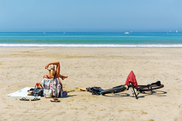 Fototapeta na wymiar Woman and bicycle in Île de Ré beach