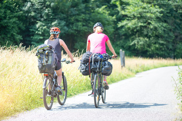 Two girls practice cycling on a bike path