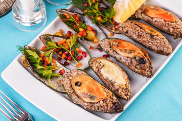 European cuisine, Mediterranean dish. Plate of assorted mussels and oysters cooked with spices i berries