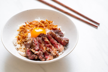 sliced beef on topped rice bowl with egg