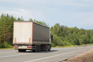 Cargo trailer in the summer goes on the highway.