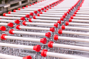 Fototapeta premium Metal trolleys in a row in the supermarket. Close-up. Space for text.