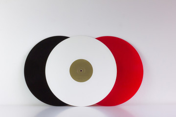 Fototapeta premium Three vinyls, black, red and white, on white background, with white space