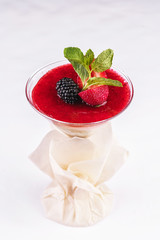 European dessert, national cuisine. Cream mousse under the jelly of red strawberries, raspberries, served with currants, mint and strawberries in a glass