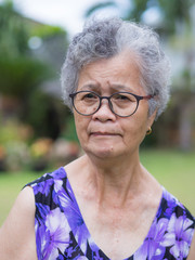 Senior woman short white hair standing in the garden
