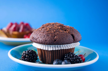 Black Chocolate Muffin isolated above blue background