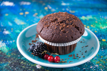 Black Chocolate Muffin isolated above blue background