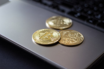 Group Bitcoin coins on laptop keyboard. Closeup side view 