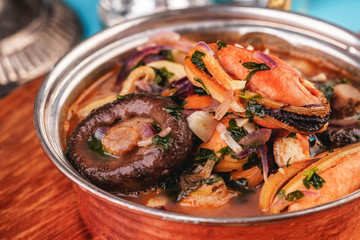 European cuisine, Italian cuisine, Mediterranean dish. Minestrone stew soup with mushrooms, fish meat, squids, mussels, greens, tomatoes and shrimps