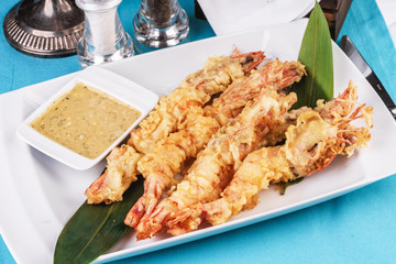 European cuisine, Mediterranean dish. Whole prawns fried in butter and batter snack for beer with cream-mustard sauce