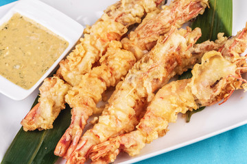 European cuisine, Mediterranean dish. Whole prawns fried in butter and batter snack for beer with cream-mustard sauce