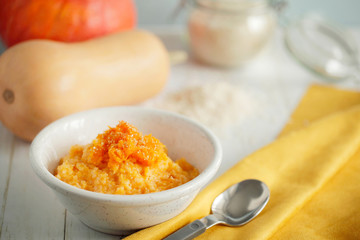 Traditional sweet rice porridge with baked pumpkin in white bowl for thanksgiving day close-up with copy space for text.Healthy vegetarian food.Selective focus.Horizontal orientation