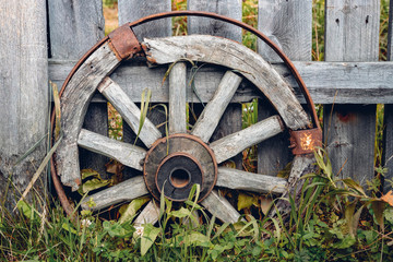 Wooden Wheel standing about Barn Wall