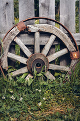 Wooden Wheel standing about Barn Wall