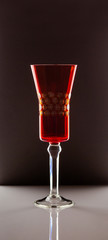 red glass stands on a white table against a dark background
