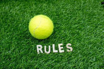 Rules of tennis with tennis ball are on green grass