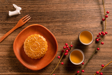 Creative Moon cake Mooncake table design - Chinese traditional pastry with tea cups on wooden background, Mid-Autumn Festival concept, top view, flat lay.