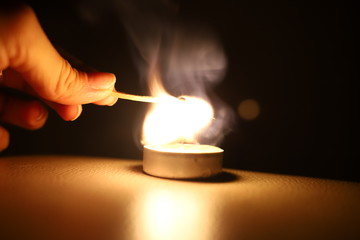 lighting a match candle dark
