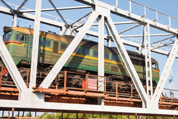 Train runs through the  railway bridge over the river