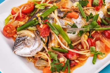 Seafood, Mediterranean cuisine. Baked sea fish with mushrooms, herbs, carrots, millers, cilantro, corn and onions. Caucasian national cuisine