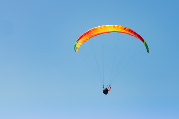 Uomo in parapendio su sfondo azzurro