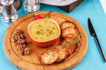 Mediterranean dish, European cuisine. Fish and cream cheese soup with herbs, garlic bread, red and green chili peppers, thyme and walnuts