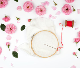 round wooden hoop and a red thread with a needle