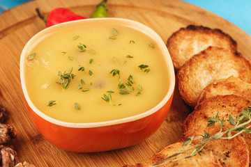 Mediterranean dish, European cuisine. Fish and cream cheese soup with herbs, garlic bread, red and green chili peppers, thyme and walnuts