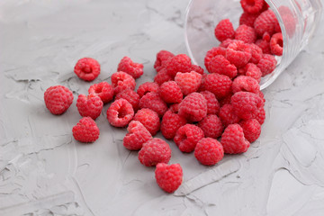ripe juicy raspberry crumbled out of a glass.