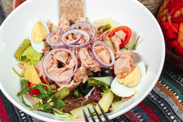 Fish salad of tuna, vegetables, tomatoes, peppers, onion rings, eggs, cabbage, lettuce and asparagus in the Georgian style. National cuisine