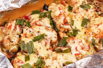 Seafood, Mediterranean cuisine, European dish. Fish baked in a foil with tomatoes, entirely with onion rings, red and green peppers, chili peppers, greens, cheese, mushrooms and vegetables. Caucasian 