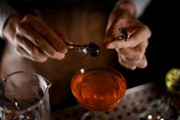 Close-up of olive on the skewer in bartender's hands
