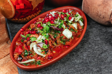 goulash from beef, veal and vegetables - tomato, cabbage, potatoes, served with greens and pomegranate seeds, Georgian appetizer. National cuisine