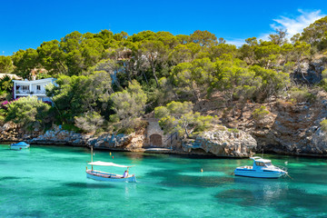 Fototapeta na wymiar Mediterranean rocky coast with motor boats in the emerald-colored sea