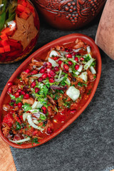 goulash from beef, veal and vegetables - tomato, cabbage, potatoes, served with greens and pomegranate seeds, Georgian appetizer. National cuisine