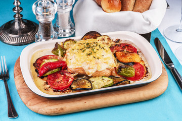 Mediterranean dish, Georgian recipe. Baked chicken steak with lemon, vegetables, pepper, zucchini, eggplants and grilled tomatoes with spices
