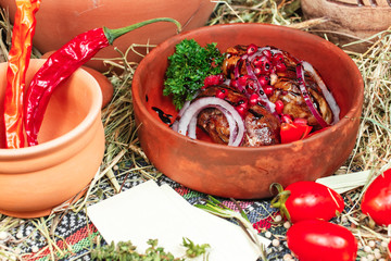 roasted meat on a roasting pan of lamb, veal, in its own juice, served with onions and pomegranate grains in Georgian. National cuisine