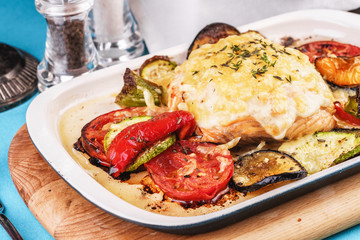 Mediterranean dish, Georgian recipe. Baked chicken steak with lemon, vegetables, pepper, zucchini, eggplants and grilled tomatoes with spices